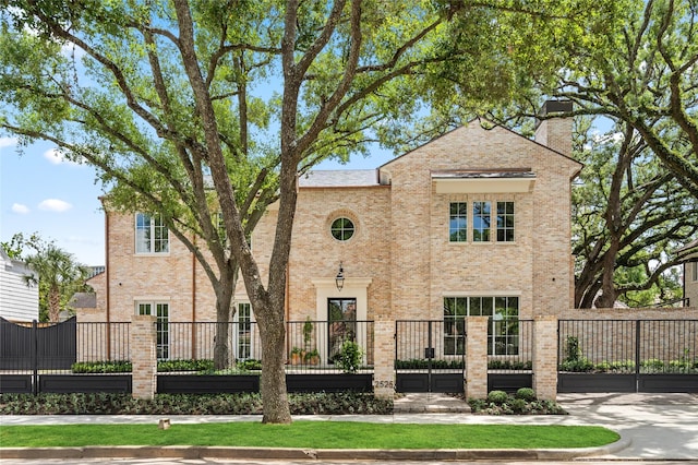 2525 Inwood Dr, Houston, TX 77019 - view of front facade with a fenced front yard, brick siding, a chimney, and a gate