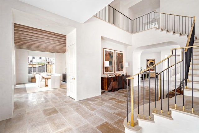 2525 Inwood Dr, Houston, TX 77019 - foyer entrance featuring stairs, arched walkways, a high ceiling, and stone finish floors