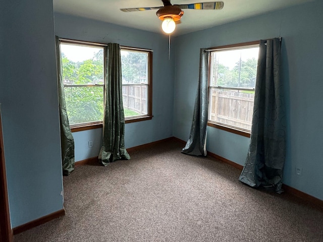 carpeted empty room featuring baseboards and a ceiling fan
