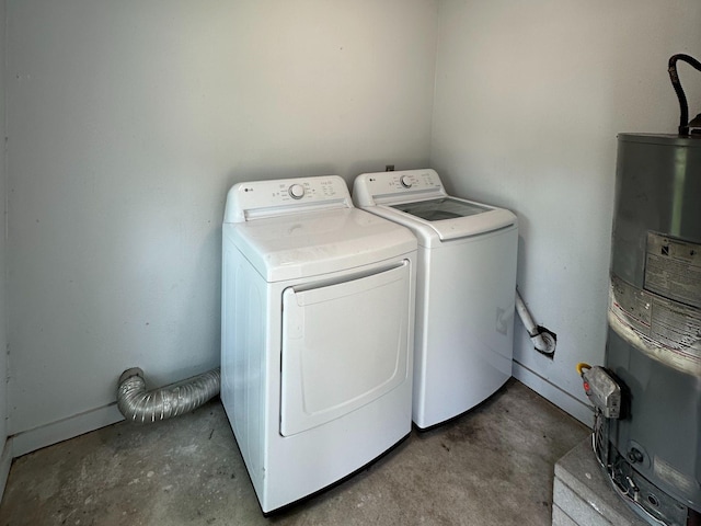 washroom featuring washing machine and clothes dryer, water heater, and laundry area