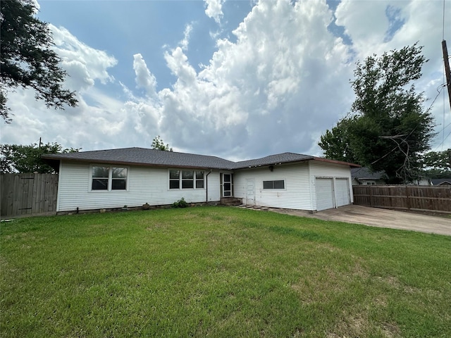 view of front of house featuring a front yard, driveway, a garage, and fence
