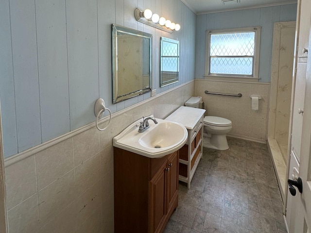 full bathroom featuring a stall shower, toilet, ornamental molding, tile walls, and vanity