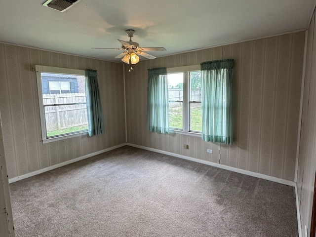 carpeted spare room with a ceiling fan, visible vents, wallpapered walls, and baseboards