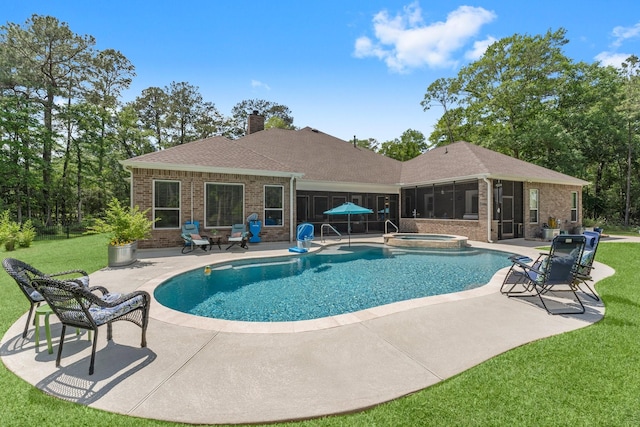 view of pool featuring a pool with connected hot tub, a lawn, a sunroom, and a patio area
