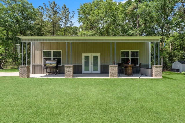 rear view of property with french doors, a yard, and a patio area