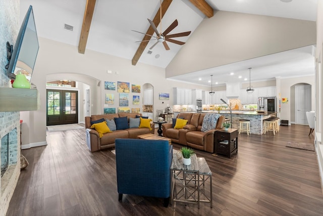 living room with arched walkways, high vaulted ceiling, a ceiling fan, and beam ceiling