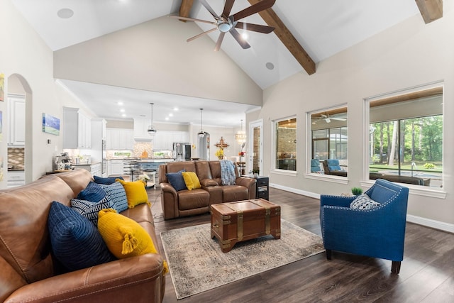 living area with beam ceiling, ceiling fan, high vaulted ceiling, dark wood-type flooring, and arched walkways