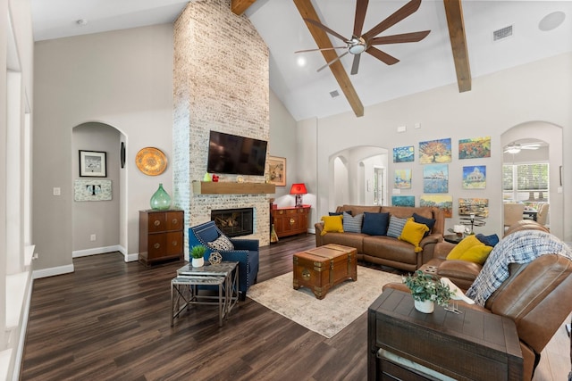living area with visible vents, dark wood-style floors, arched walkways, a ceiling fan, and high vaulted ceiling