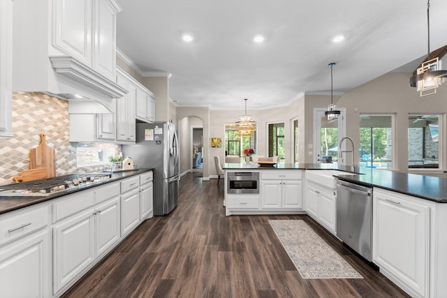 kitchen featuring stainless steel appliances, dark countertops, dark wood-type flooring, and a sink