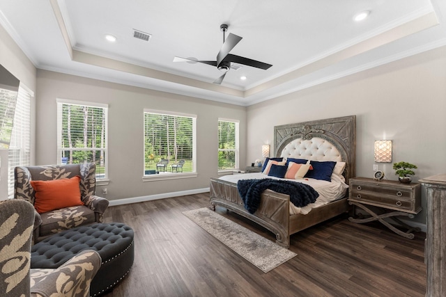 bedroom with a raised ceiling, visible vents, baseboards, ornamental molding, and wood finished floors
