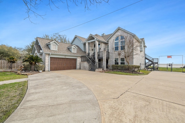 traditional home featuring driveway, fence, stairs, and a garage