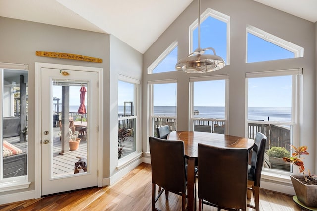 sunroom featuring a water view and french doors