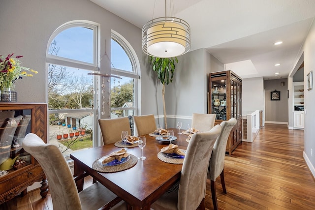 dining area with hardwood / wood-style flooring, recessed lighting, and baseboards