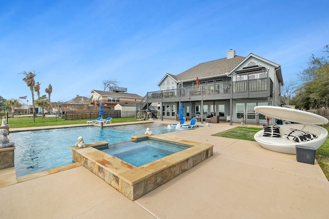 view of swimming pool featuring a pool with connected hot tub, a patio area, french doors, and a fenced backyard