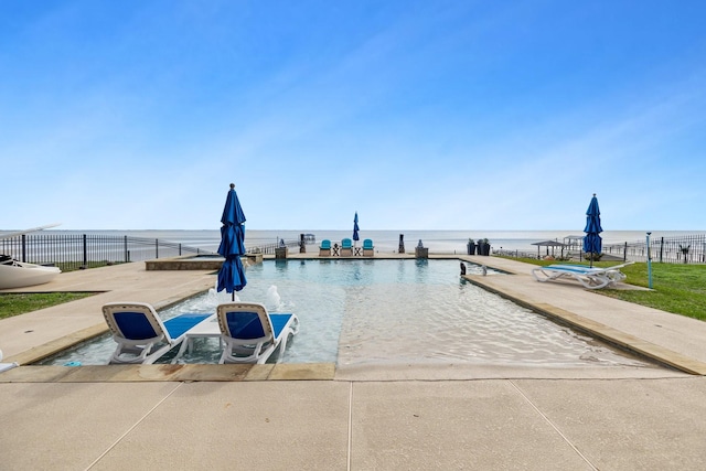 pool featuring fence, a water view, and a patio area