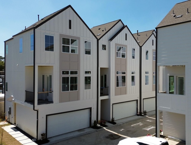 multi unit property featuring board and batten siding, concrete driveway, and a garage