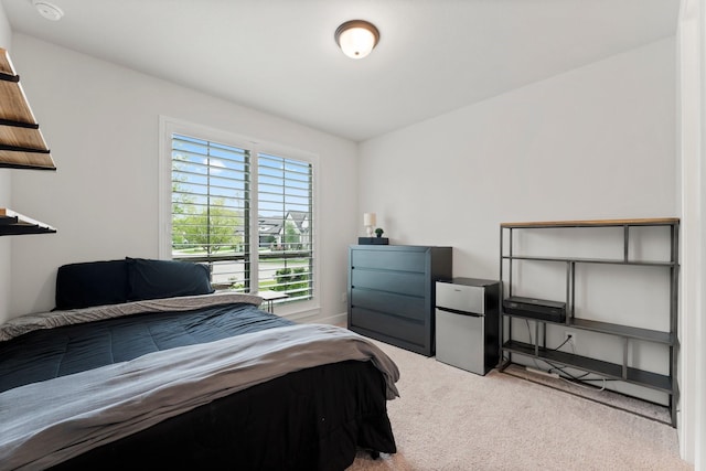 bedroom with freestanding refrigerator and carpet floors