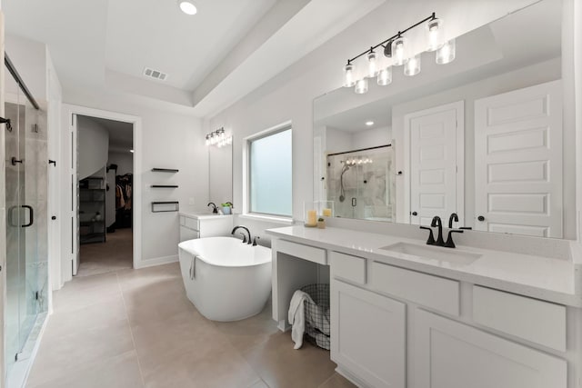 bathroom featuring visible vents, a freestanding tub, tile patterned flooring, a shower stall, and vanity