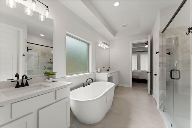 ensuite bathroom with a ceiling fan, a sink, a soaking tub, and a stall shower