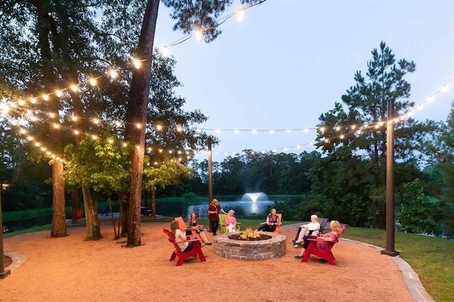 view of property's community featuring a water view and an outdoor fire pit