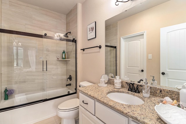 full bathroom featuring combined bath / shower with glass door, toilet, vanity, and tile patterned flooring
