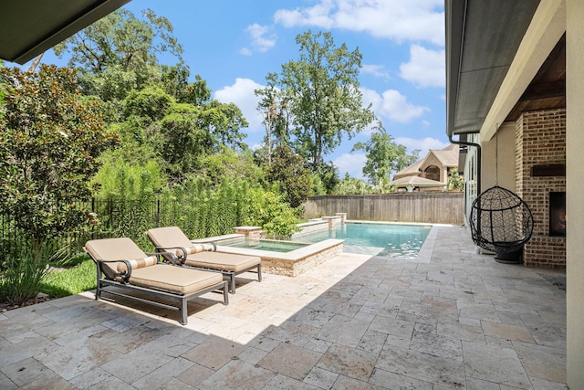 view of pool with an outdoor hot tub, a patio area, and a fenced backyard