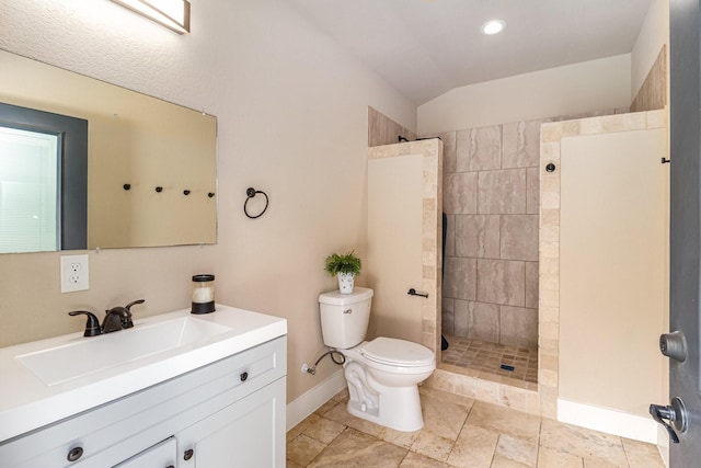 bathroom featuring toilet, a walk in shower, baseboards, vanity, and vaulted ceiling