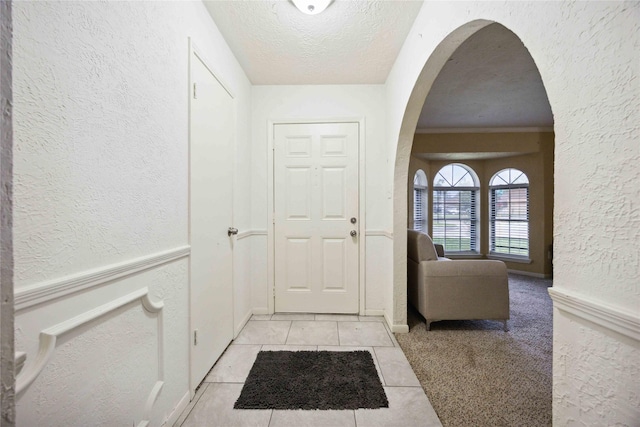 255 Shekel Ln, Houston, TX 77015 - interior space with light tile patterned floors, arched walkways, a textured wall, and a textured ceiling