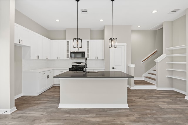 416 Stonework Landing Ln, Houston, TX 77076 - kitchen with visible vents, appliances with stainless steel finishes, an island with sink, and white cabinetry