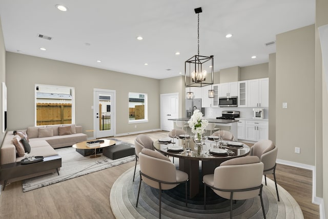 416 Stonework Landing Ln, Houston, TX 77076 - dining space with visible vents, a chandelier, baseboards, recessed lighting, and light wood finished floors