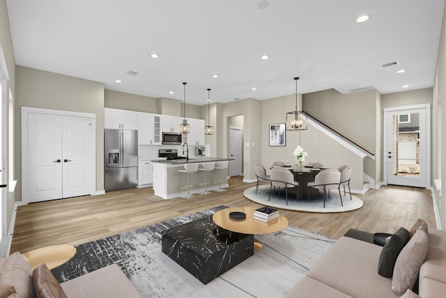 416 Stonework Landing Ln, Houston, TX 77076 - living area with visible vents, stairway, light wood finished floors, and recessed lighting