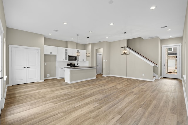 416 Stonework Landing Ln, Houston, TX 77076 - unfurnished living room with a sink, recessed lighting, visible vents, and light wood-style floors