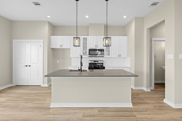 416 Stonework Landing Ln, Houston, TX 77076 - kitchen featuring visible vents, white cabinetry, stainless steel appliances, and baseboards