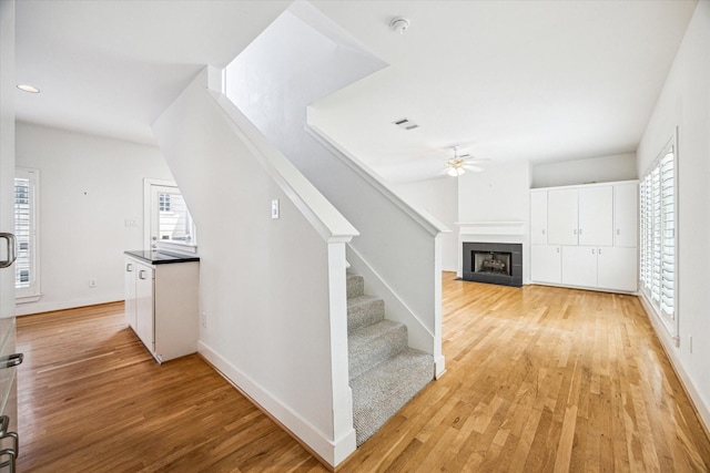 242 Knox St, Houston, TX 77007 - interior space with ceiling fan, a tiled fireplace, light wood finished floors, and stairs