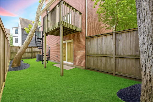 242 Knox St, Houston, TX 77007 - rear view of house featuring central air condition unit, a lawn, stairway, brick siding, and a fenced backyard