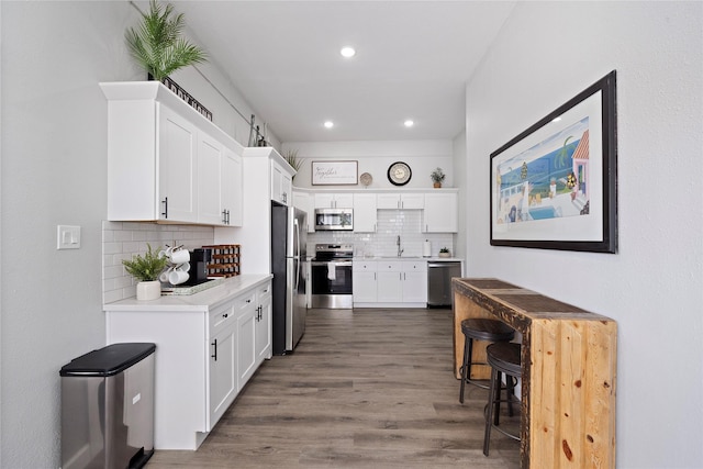 1101 Moody Ave, Galveston, TX 77550 - kitchen with white cabinetry, appliances with stainless steel finishes, light countertops, recessed lighting, and backsplash
