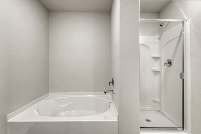 bathroom with a garden tub and a shower stall