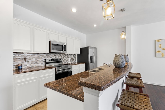 kitchen featuring white cabinets, stainless steel appliances, a sink, and tasteful backsplash