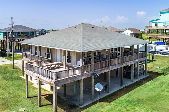 138 Verdia Dr, Crystal Beach, TX 77650 - back of house with a lawn, roof with shingles, a deck, and a patio area