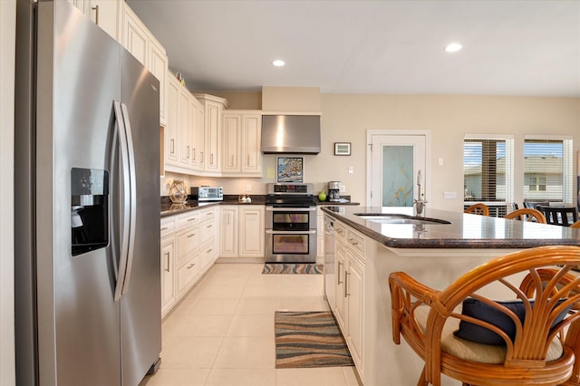138 Verdia Dr, Crystal Beach, TX 77650 - kitchen with recessed lighting, appliances with stainless steel finishes, wall chimney range hood, a sink, and light tile patterned flooring