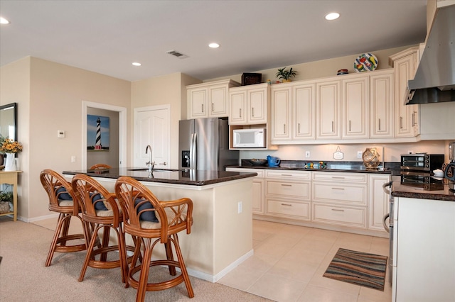 138 Verdia Dr, Crystal Beach, TX 77650 - kitchen featuring a sink, visible vents, white microwave, wall chimney range hood, and stainless steel fridge with ice dispenser