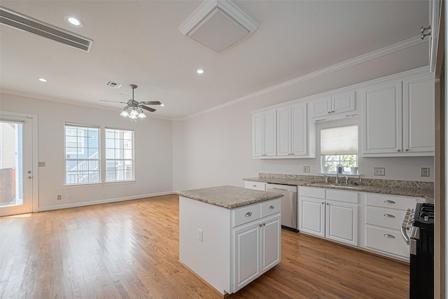 kitchen with stainless steel dishwasher, a sink, visible vents, gas range, and ornamental molding