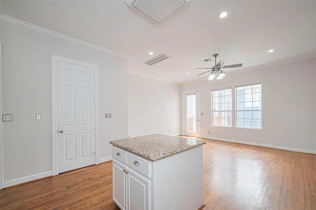 kitchen with light wood-style flooring, ornamental molding, ceiling fan, baseboards, and visible vents