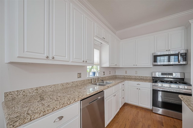 kitchen with a sink, white cabinetry, and stainless steel appliances