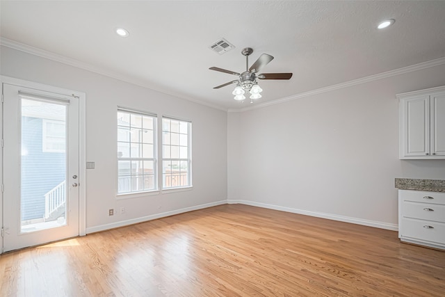 interior space with crown molding, ceiling fan, baseboards, and light wood-style floors