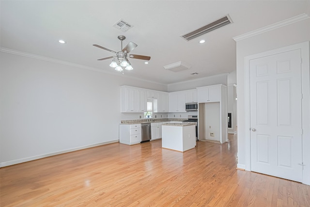 kitchen with white cabinetry, crown molding, visible vents, stainless steel appliances, and a ceiling fan