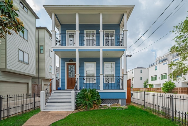 view of front of property with covered porch, fence, a residential view, a balcony, and an attached garage