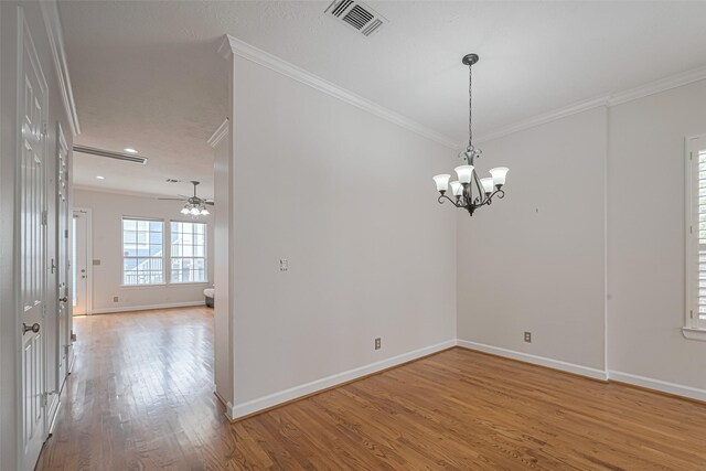 empty room with ornamental molding, visible vents, light wood-style flooring, and baseboards