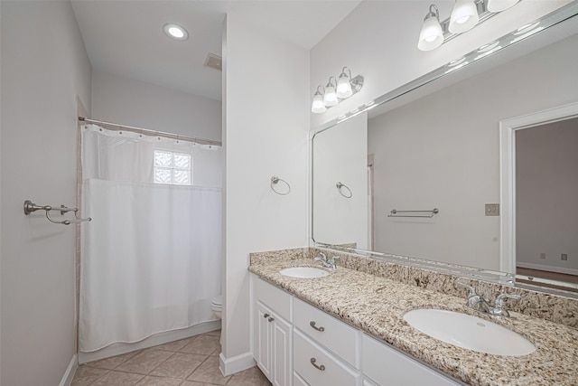 bathroom featuring baseboards, toilet, and a sink