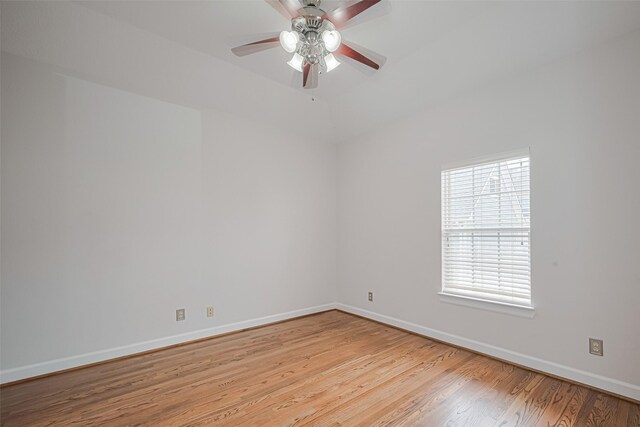 empty room featuring baseboards, a ceiling fan, and light wood-style floors
